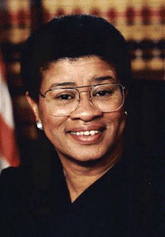Judge_Alice_Athenia_Lytle__Courtesy_Superior_Court_of_California_Sacramento Woman with medium short hair and glasses. Out of focus background and American flag.